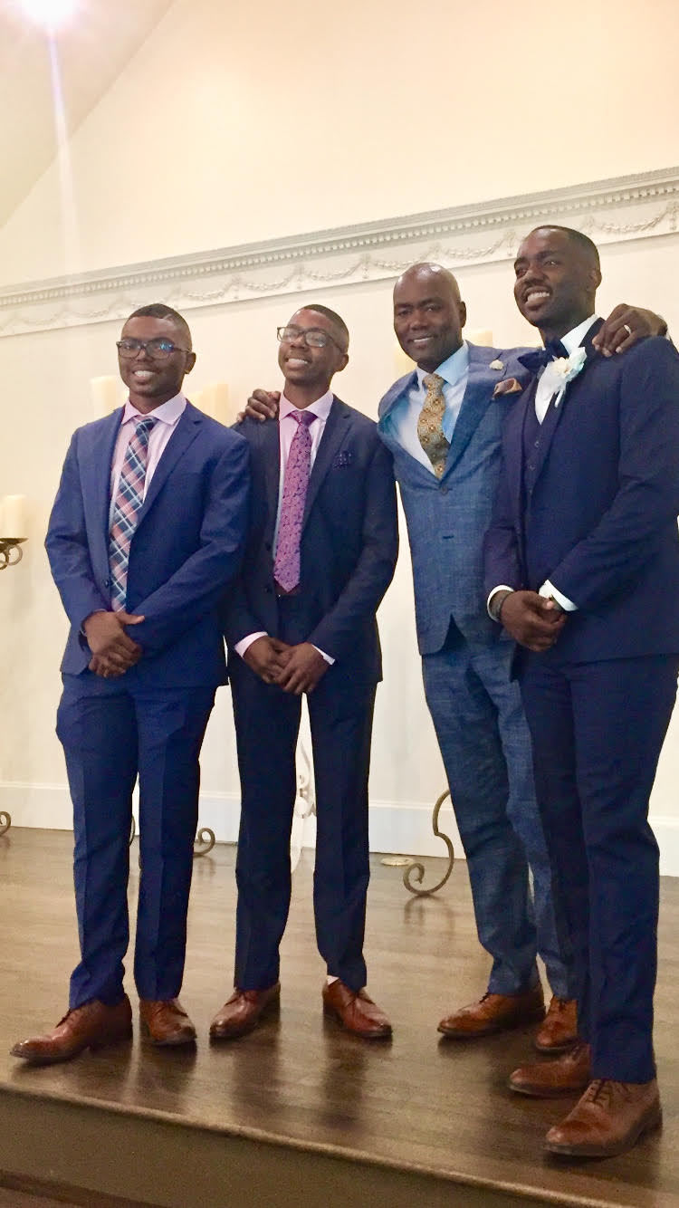 Young men in suits with their mentors at a FAST rite of passage ceremony